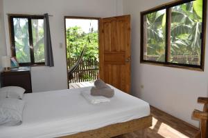 Pacifico Surf Bayay的一间卧室设有床、两个窗户和一扇门