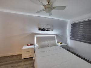 蒙特利尔4 Bedrooms Beautiful Townhouse的卧室配有白色的床和吊扇