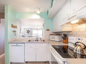 泰比岛Tybee Lights 110C的厨房配有白色橱柜和水槽