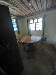 平圭Bibi Mrembo Guesthouse的客房设有桌椅和窗户。