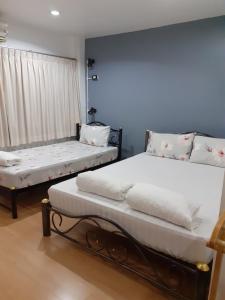 曼谷班素青年旅舍的一间卧室设有两张床和窗户。