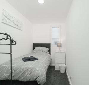 Apex Living NE - Carnegie House 4 Bed House, FREE PARKING FREE WiFi的白色的卧室设有床和窗户