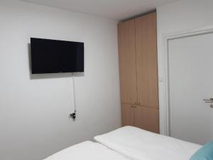 Or YehudaAirport Guest House的一间白色墙壁上配有电视的卧室