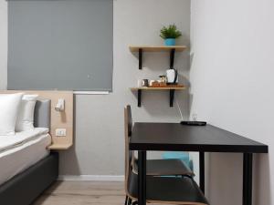 Or YehudaAirport Guest House的一间卧室配有书桌、一张床和一张桌子