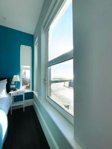 滨海戈尔斯顿Coral House的一间卧室设有大窗户、一张床和一张书桌