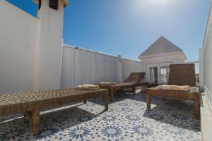 索维拉Riad Dar Abi的阳台设有3张长椅,铺有瓷砖地板