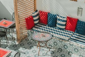索维拉Riad Dar Abi的客房设有一张带色彩缤纷枕头的沙发和一张桌子。