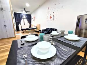 马六甲The Quartz Premium Travel Suites @Melaka的一间用餐室,配有黑桌和白板