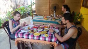 迪克韦勒The ED Corner - Hiriketiya的一群坐在餐桌上吃食物的人