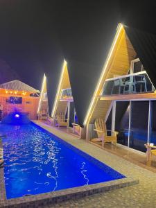 佩德纳莱斯Villa completa confotable para 9 personas的一座晚上设有游泳池的房子