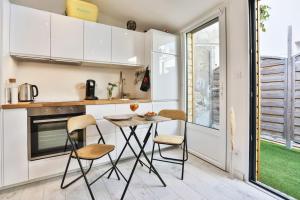 莱萨布勒-多洛讷Tiny studio terrasse, hypercentre la plage à 2 pas !的厨房配有桌椅和窗户。