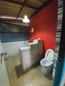 北冲北冲版衫理南度假村的一间带卫生间和红色墙壁的浴室