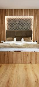 萨拉热窝Apartments "Tuffo"的一间卧室设有一张带木墙的大床