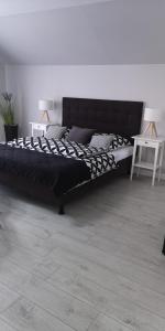 米兹多洛杰Villa Basia的一张黑色大床,位于带两张桌子的房间