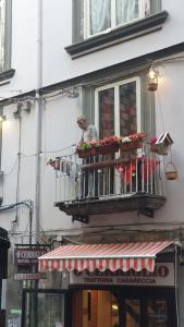 那不勒斯casa vacanze a casa di ciro的坐在建筑物阳台的人
