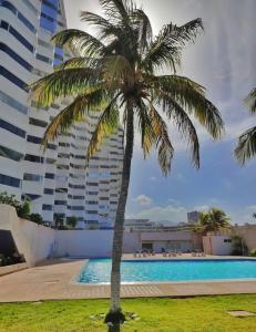 波拉马尔*Tulli Apartmentos Margarita Island*的一座大建筑前的棕榈树