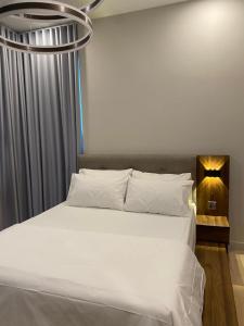 吉隆坡Datum Jelatek Sky Residence KLCC SkyRing Linked to LRT and Mall的卧室配有一张带吊灯的大型白色床。