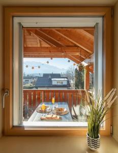 图恩Swiss Alps View Apartment - contactless self check-in的房屋内的窗户,配有餐桌、食物和酒杯