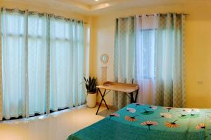 PataoDJL House Homestay -Bantayan Island的卧室配有床、桌子和窗户。