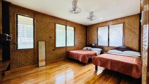 圣维森特Gilligans Port Barton Beach Resort的带两张床和两个窗户的房间