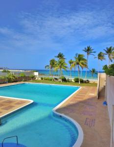 波拉马尔*Tulli Apartmentos Margarita Island*的一座棕榈树和海洋游泳池