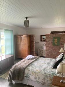 布雷达斯多普Ou Werf Farm Cottage的一间卧室设有一张大床和砖墙