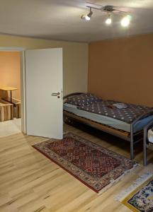 内卡河畔劳芬KRW Location的一间卧室配有一张床,一扇门铺有地毯