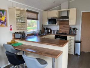 维斯贝希Honeybee Lodge的厨房配有木制台面和椅子