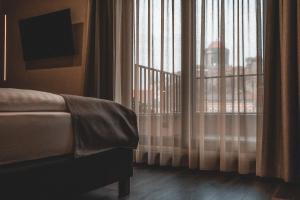 艾斯特根Mediterraneo Luxury Room Esztergom的一间卧室配有床和带窗帘的窗户