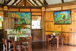 图里亚尔瓦Cabañas el Bosque的用餐室配有桌椅,墙上挂有绘画作品