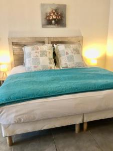 GriesMaison d'hôtes Aux Deux Cigognes的一间卧室配有一张带蓝色床单和枕头的床。