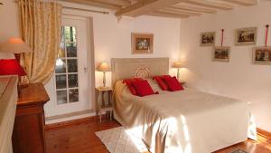 吉维尼A l'Ombre du Tilleul的卧室配有带红色枕头的大型白色床