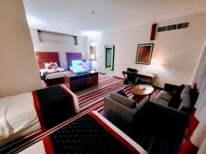 多哈Wonder Palace Hotel Qatar的酒店客房设有带一张床和电视的客厅。