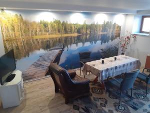 FilipówZacisze nad Rospudą的一间设有桌子和湖画的用餐室