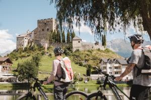 拉迪斯Alpine Resort Goies Superior的一群人站在城堡前骑着自行车