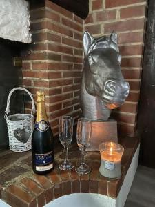 ChaonLa demeure du Cerf gîte de charme privatif 6P en Sologne Jacuzzi Piscine chauffée sud Orléans Beauval的一只猪的雕像,配上两杯眼镜和一瓶香槟