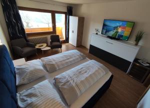 米尔施塔特祖姆穆尔拉德膳食公寓的一间卧室配有两张床和一台平面电视