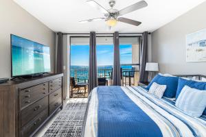 奥兰治比奇Spacious Seaside Beach and Racquet 3706 with Pool and Comfort Amenities的一间卧室配有蓝色的床和一台平面电视