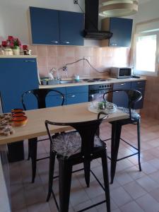 维尔DosPalmeras的厨房配有蓝色橱柜和木桌及椅子