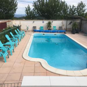 Châteauneuf-Val-Saint-DonatLe Clos des Gites, maisons de vacances,的一座带蓝色椅子的游泳池,位于大楼旁