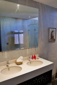 拉巴特Dar Chrifa的一间带两个盥洗盆和大镜子的浴室