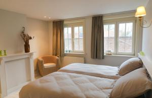 伊普尔Maison Rose的一间卧室配有一张床、一把椅子和窗户。