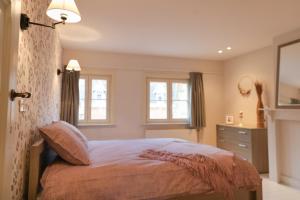 伊普尔Maison Rose的一间卧室配有一张床、梳妆台和窗户。
