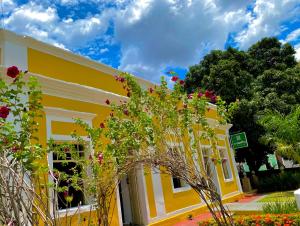 皮拉尼亚斯O Canto Pousada的前面有鲜花的黄色建筑