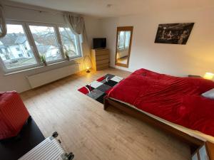 LykershausenFerienhaus Rheinnähe的一间卧室,卧室内设有一张红色的大床