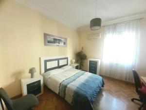 马德里Apartamento en Retiro的卧室配有床、椅子和窗户。