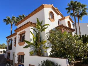 阿尔豪林格朗德Casa Limon, boutique Bed and Breakfast, Andalucia的一座棕榈树掩映的白色房子