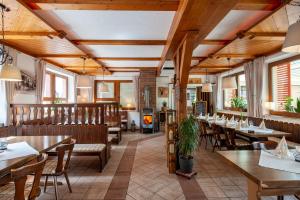 Dammbach兰德盖斯特霍夫奥博尔施诺霍夫酒店的餐厅设有木制天花板和桌椅