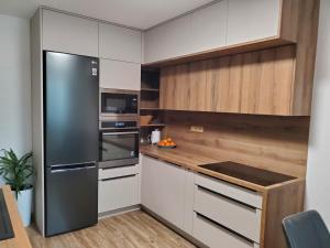 伊钦Nový apartman Eva的厨房配有不锈钢冰箱和木制橱柜