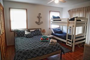 埃文Lake Front Modern Beach House-Hatteras Island的一间卧室配有一张床和一张双层床。